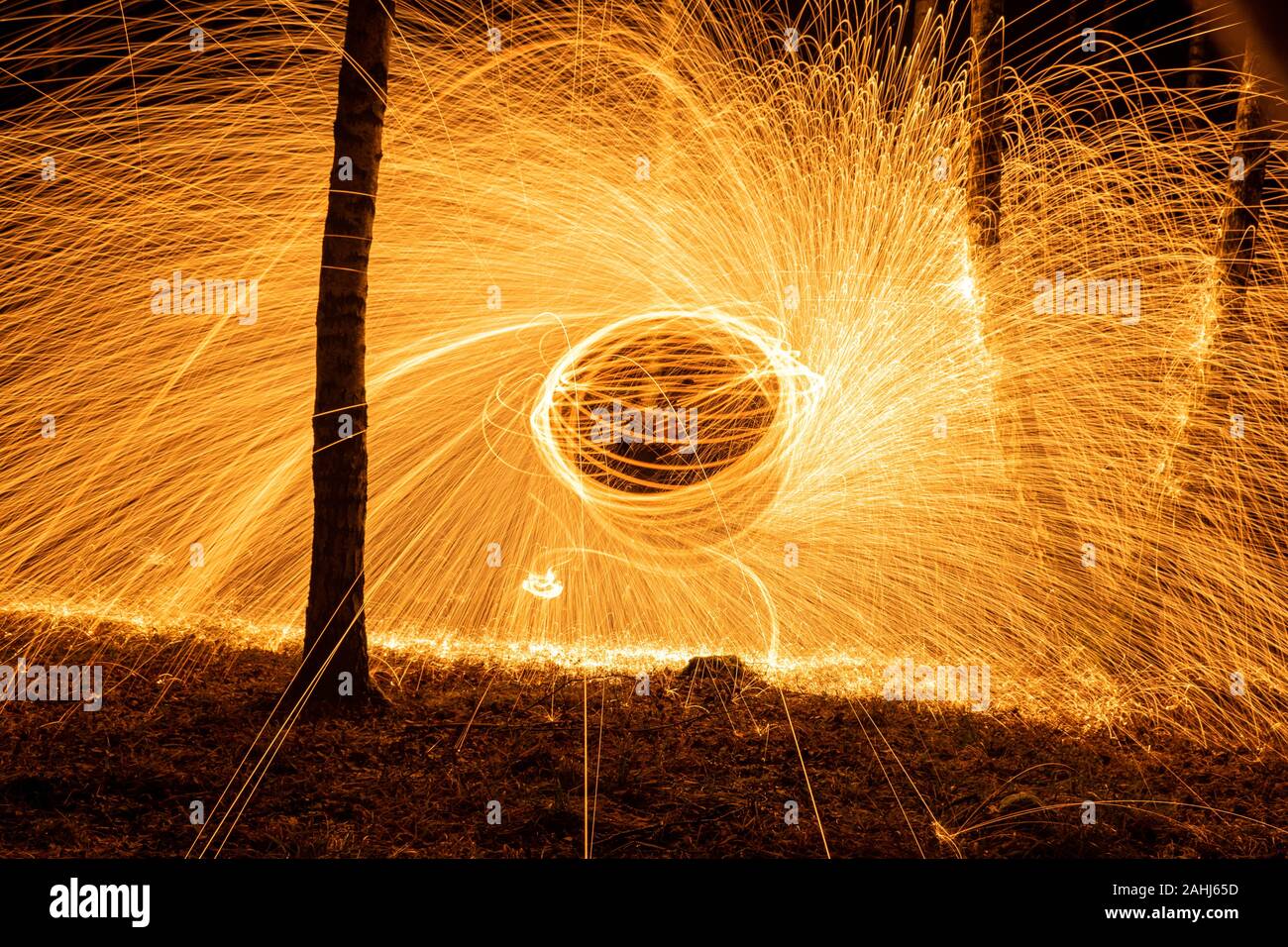 Fire circle spinning from steel wool creating spiral spark, Steel wool spinning fire circle spinning from steel wool creating spiral spark, birch grov Stock Photo