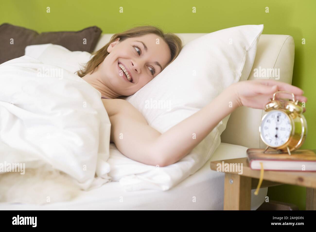 25 -30 jährige Frau schläft im Bett, zeigt ihre Füsse, MR:Yes Stock Photo