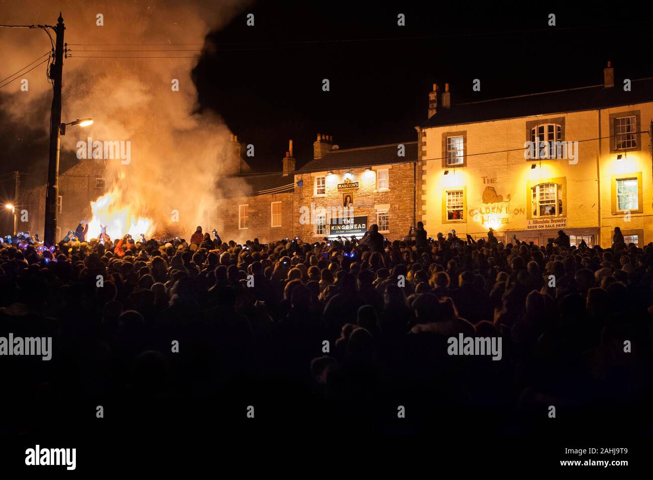Crowds at bonfire celebrate New Year at Allendale New Year's Eve Tar Bar'l ceremony where burning Tar Barrels are carried and thrown on to the fire. Stock Photo