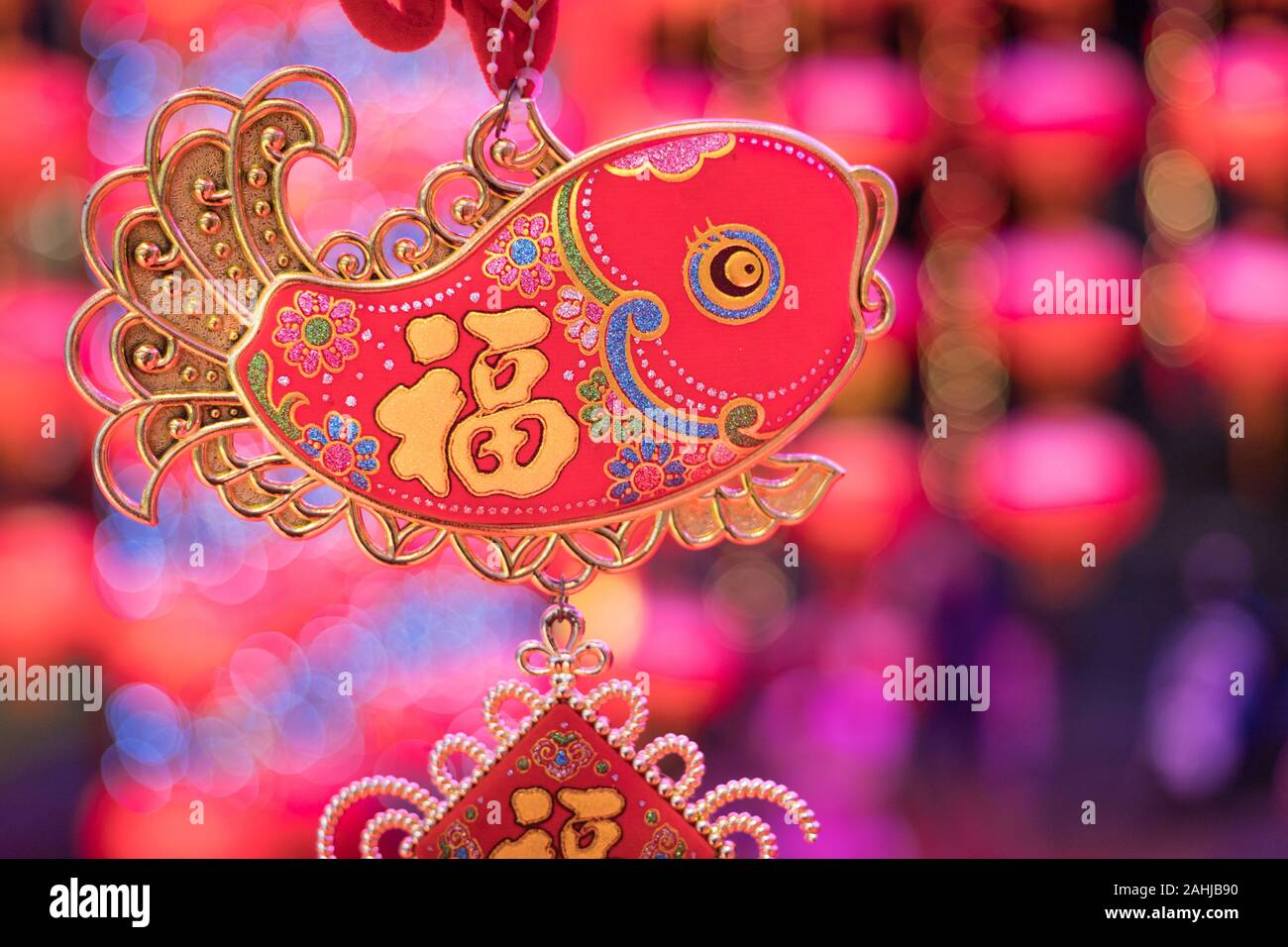 chinese symbol on fish decoration is hanging on with festival blur in background, the word mean luck Stock Photo