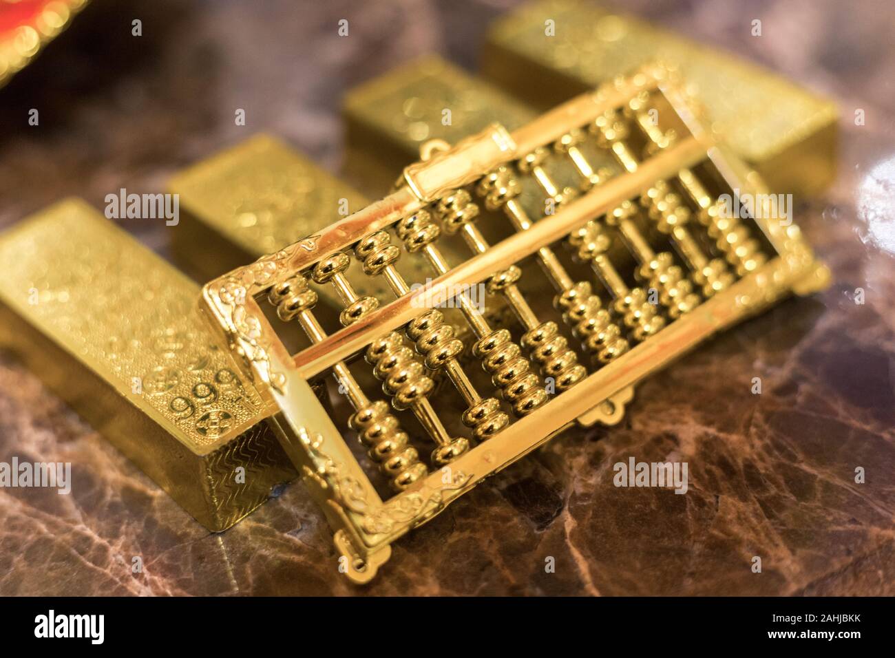 one kilo gold put on luxury marble table together in a row with golden abacus on top. closeup Stock Photo