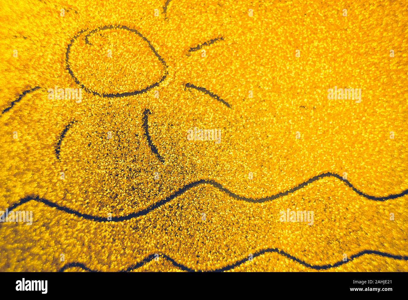 Hand drawn sun and sea waves on golden sandy background. Stock Photo