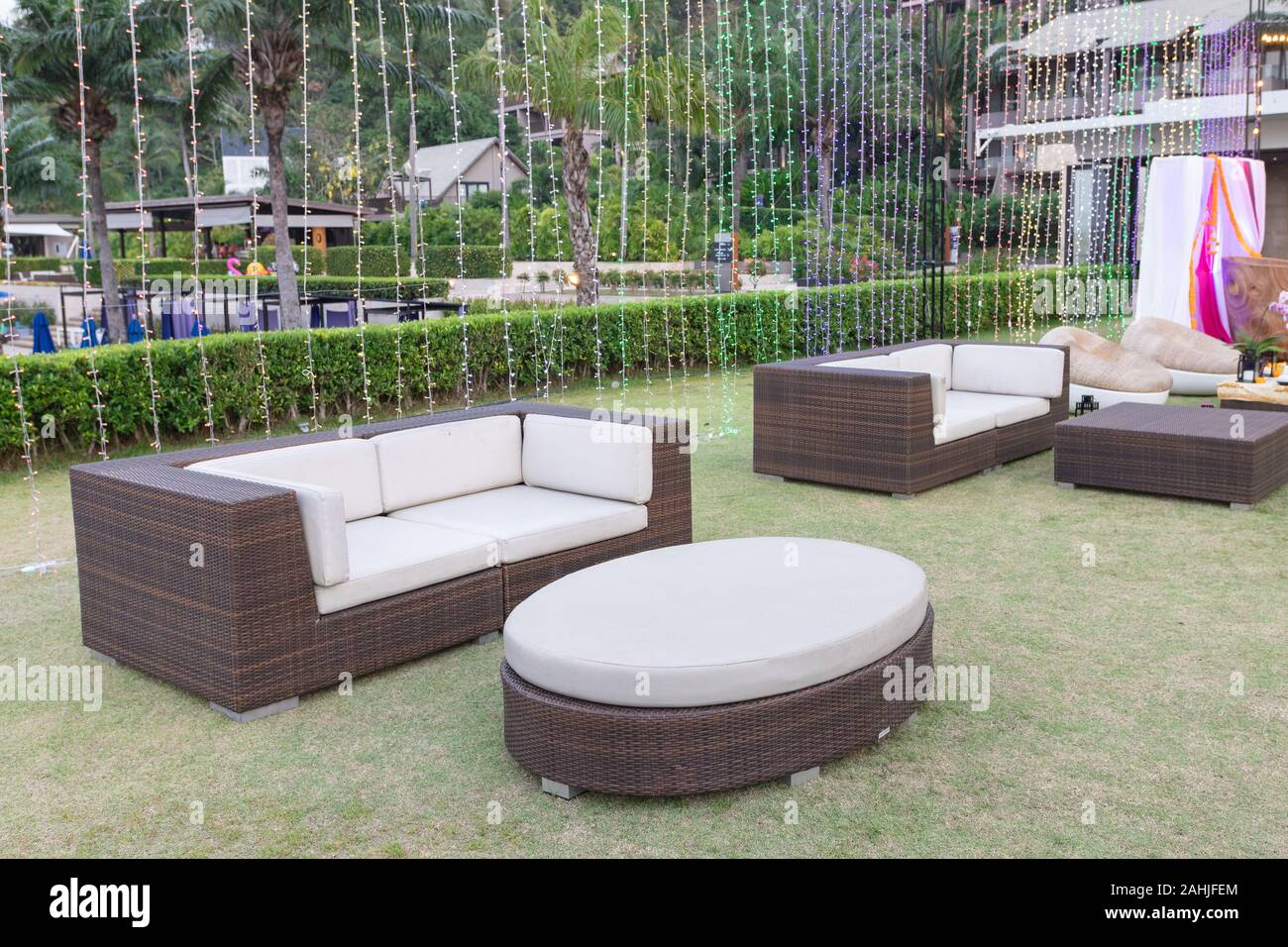 sofa set put on grass at outdoor party with led light decorate behind