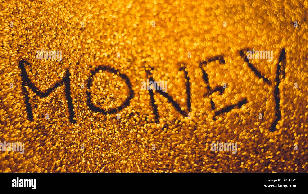 Text money on golden rich sandy background. Stock Photo