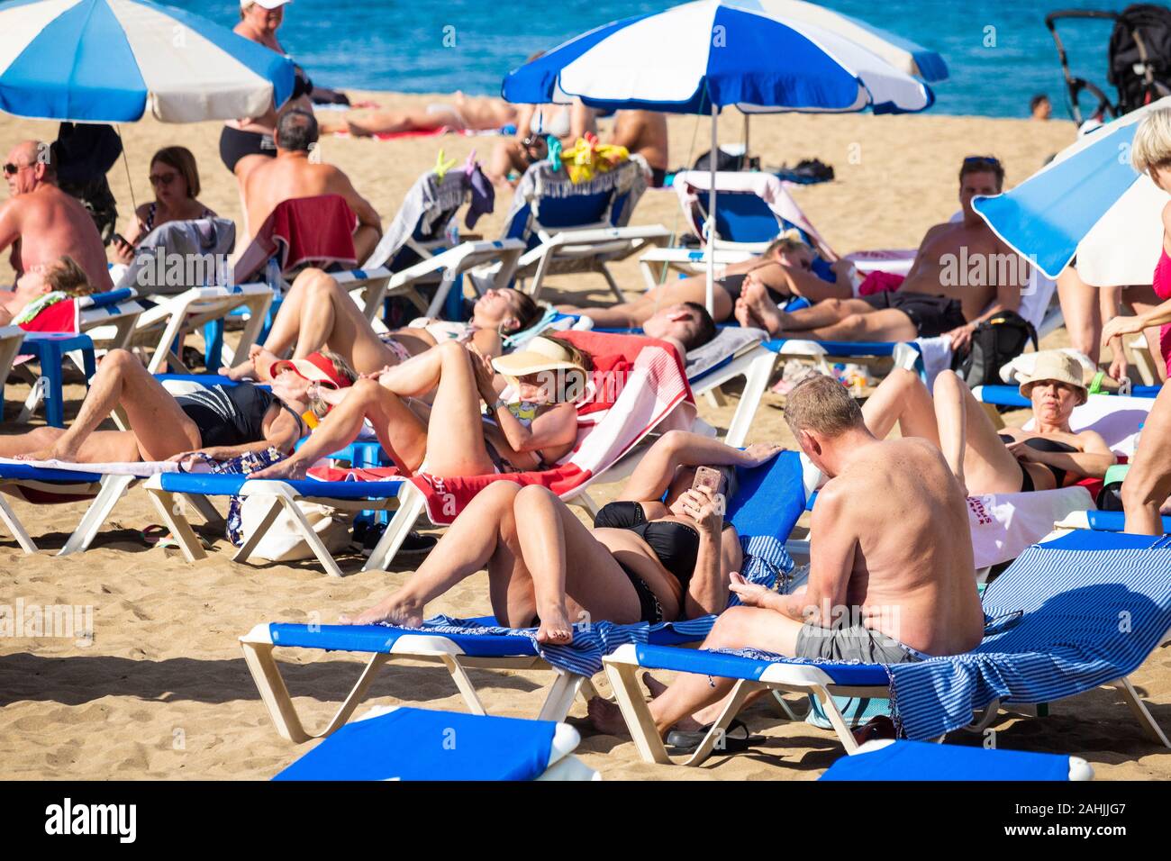 Tourists sunbathing on beach in Spain Stock Photo - Alamy