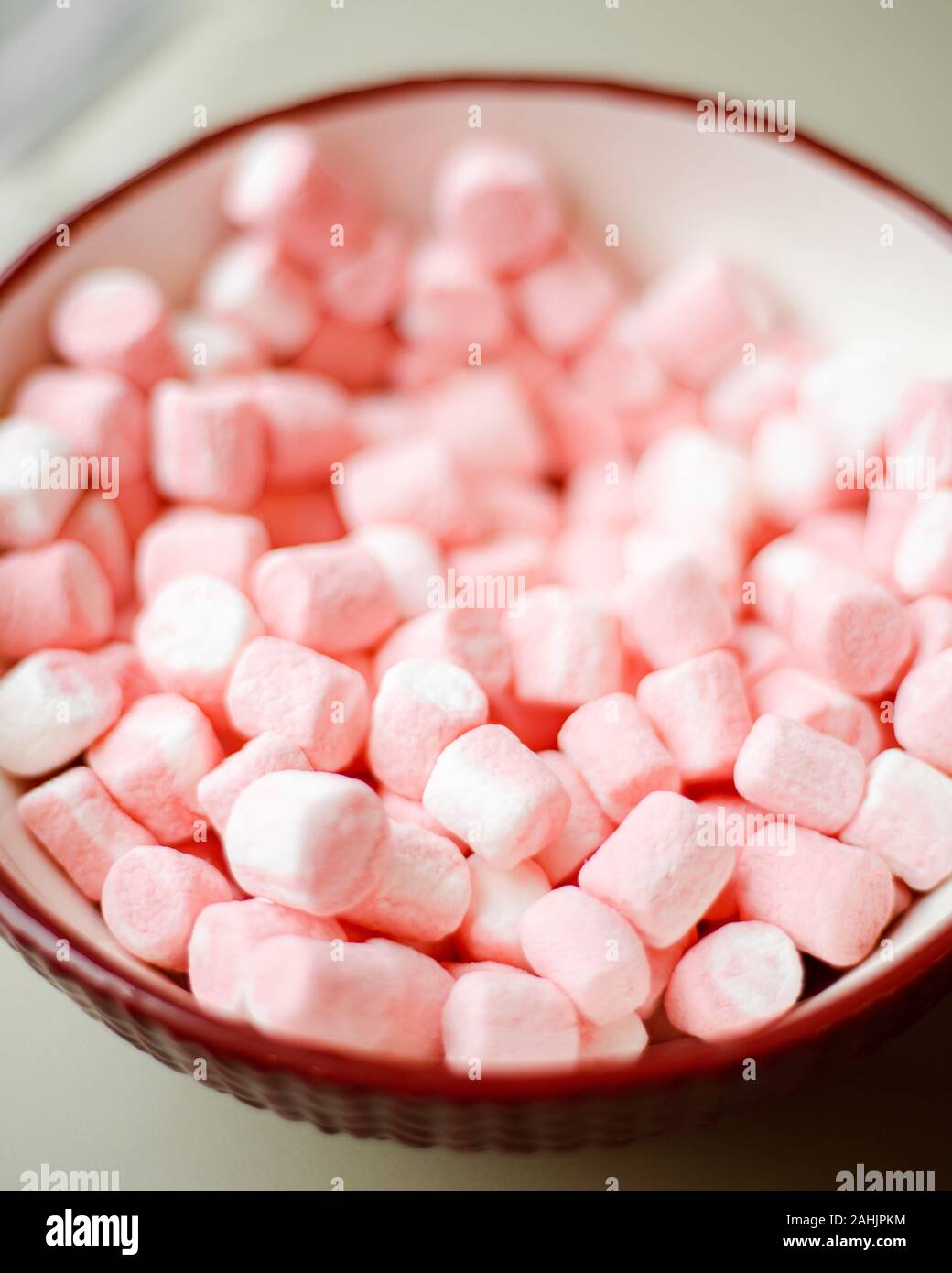 Small Pink and white Marshmallows in Red and White Bowl With Blurry Background/Shallow depth of field Stock Photo