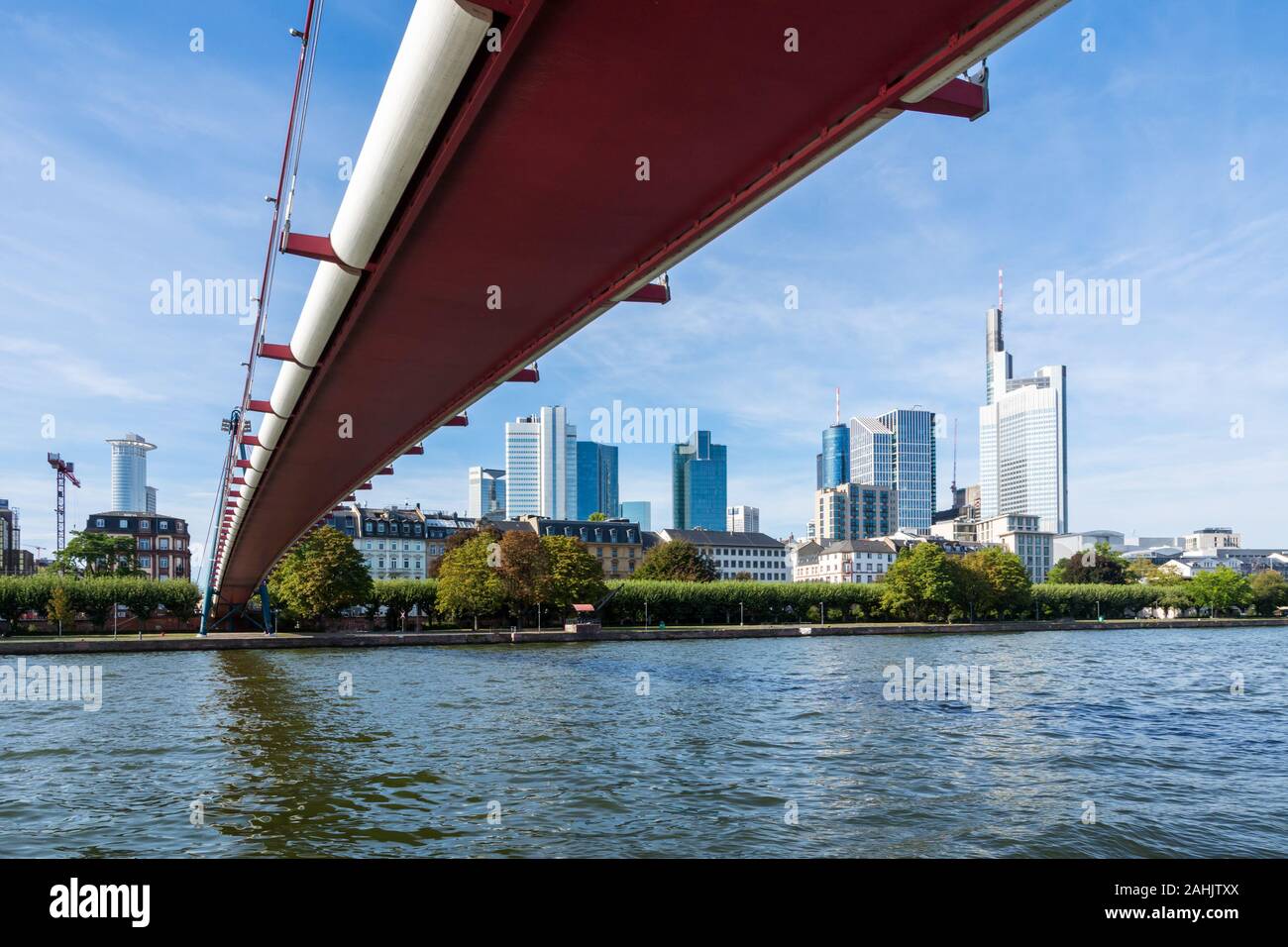 The Holbeinsteg footbridge in Frankfurt acrross Main river with view to the skyline Stock Photo