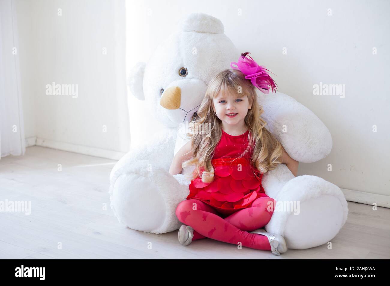 Beautiful little girl with toy big teddy bear Stock Photo - Alamy