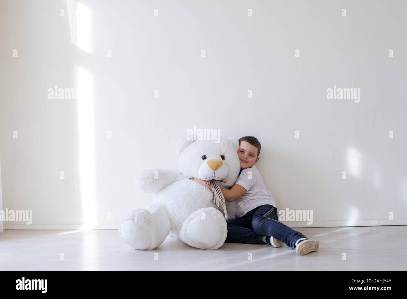 Beautiful little boy with toy big teddy bear Stock Photo - Alamy