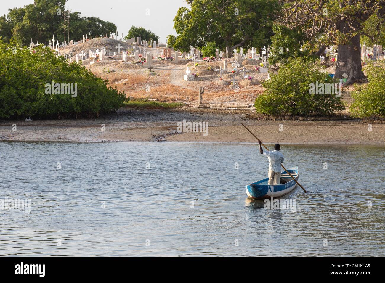 JOAL-FADIOUTH, SENEGAL - NOVEMBER15, 2019: Cemetery at Joal-Fadiouth. Christian graves and crosses next to large baobabs. Fadiauth Island. Senegal. We Stock Photo