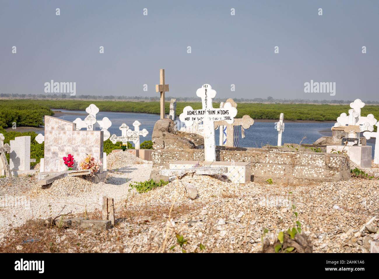 JOAL-FADIOUTH, SENEGAL - NOVEMBER15, 2019: Cemetery at Joal-Fadiouth. Christian graves and crosses next to large baobabs. Fadiauth Island. Senegal. We Stock Photo