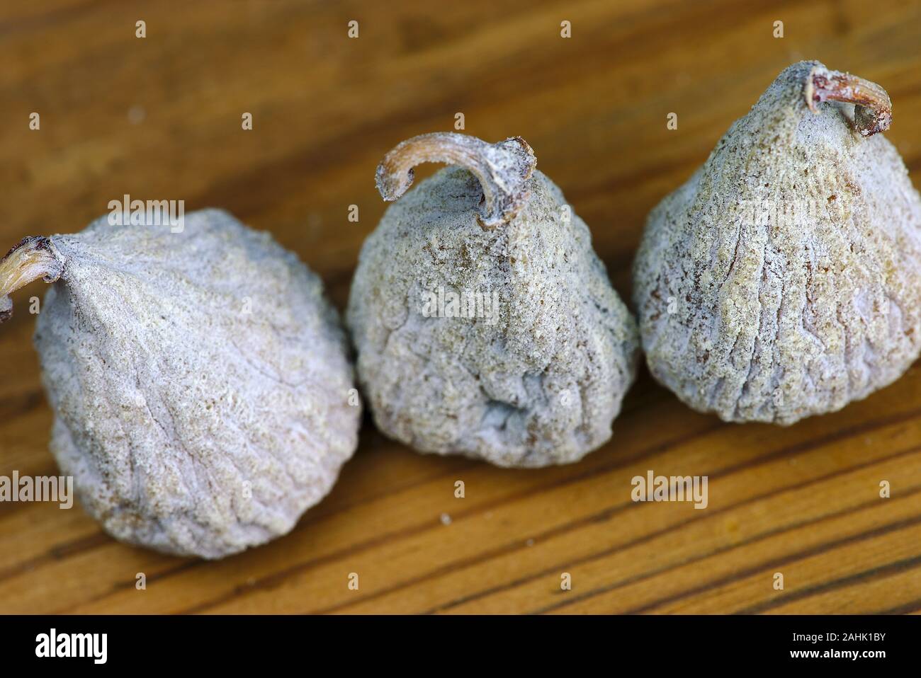 three dried figs close-up on a wooden board Stock Photo