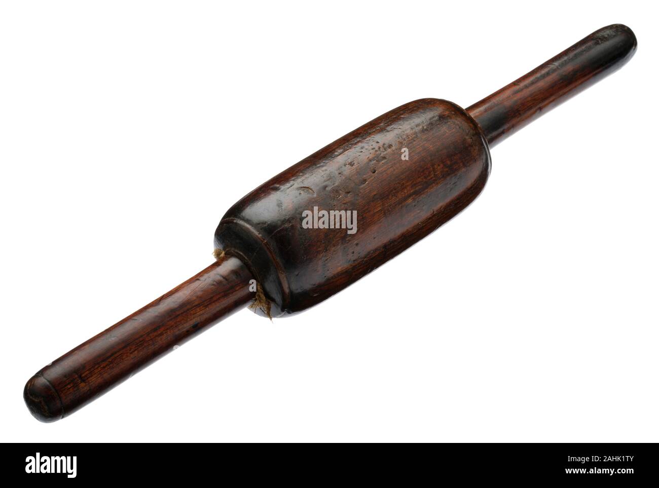 A very old wooden rolling pin. Possibly a hard wood such as Lignum Vitae. Used to roll pastry and other foods in the kitchen. Stock Photo