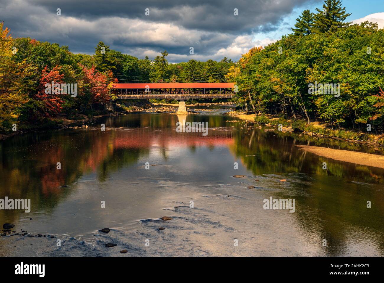 A wooden covered bridge spanning the Saco River near Conway, NH. Stock Photo