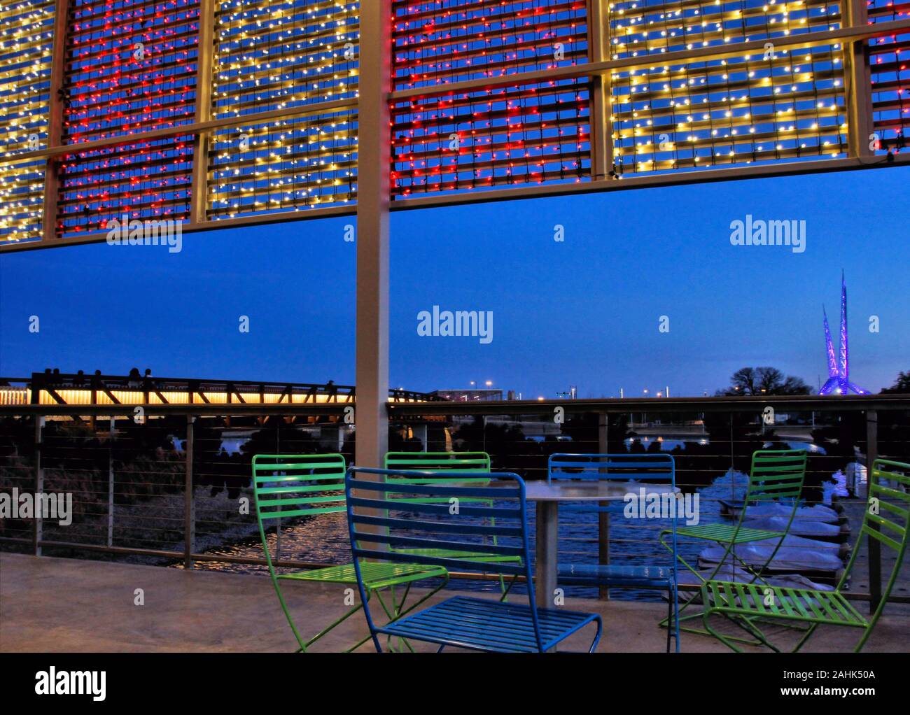 The Lake bridge, and the Skydance sculpture at Scissortail Park in Downtown Oklahoma City are viewed at sunset from the patio of the Boathouse. Stock Photo