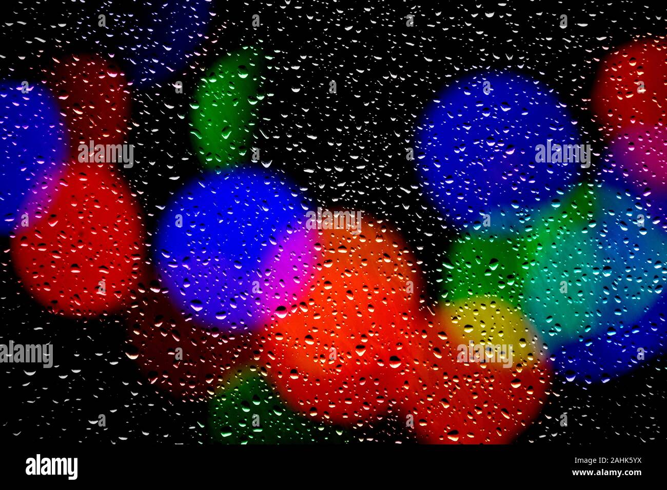 Christmas tree fairy lights seen through a window covered with