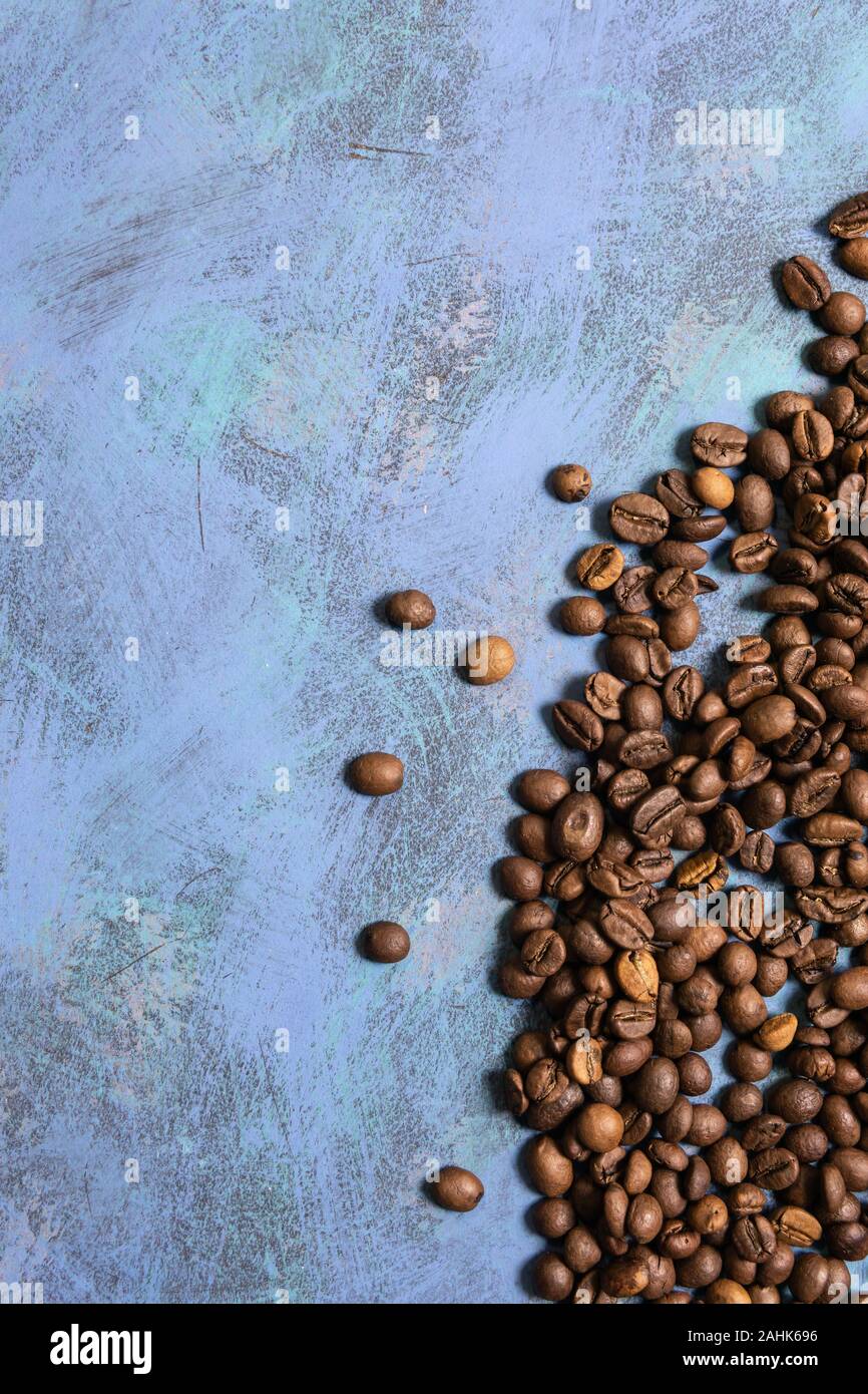 Roasted coffee beans in bulk on a blue background. dark cofee roasted ...