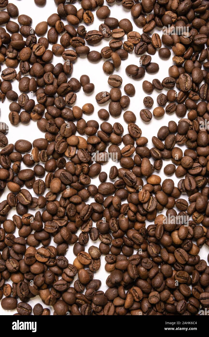 Roasted coffee beans in bulk on a light blue background Stock Photo - Alamy