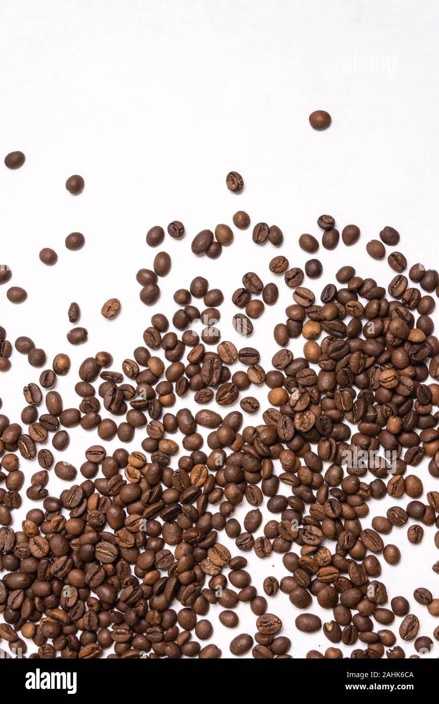 Roasted coffee beans in bulk on a light blue background. dark cofee ...