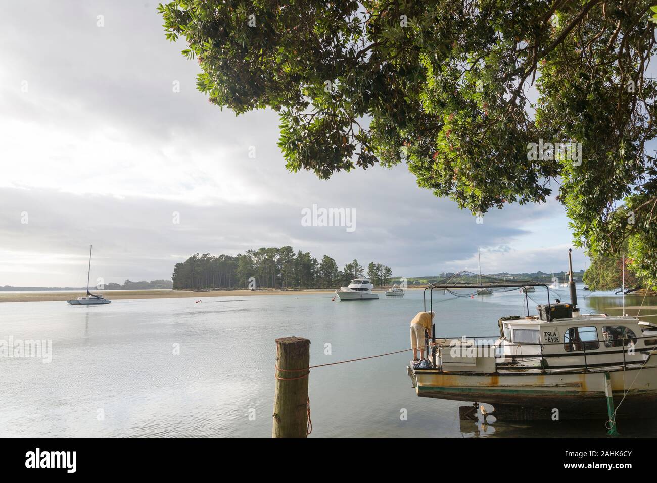 A man standing on a boat in harbour ar Tanners Point, a very sheltered