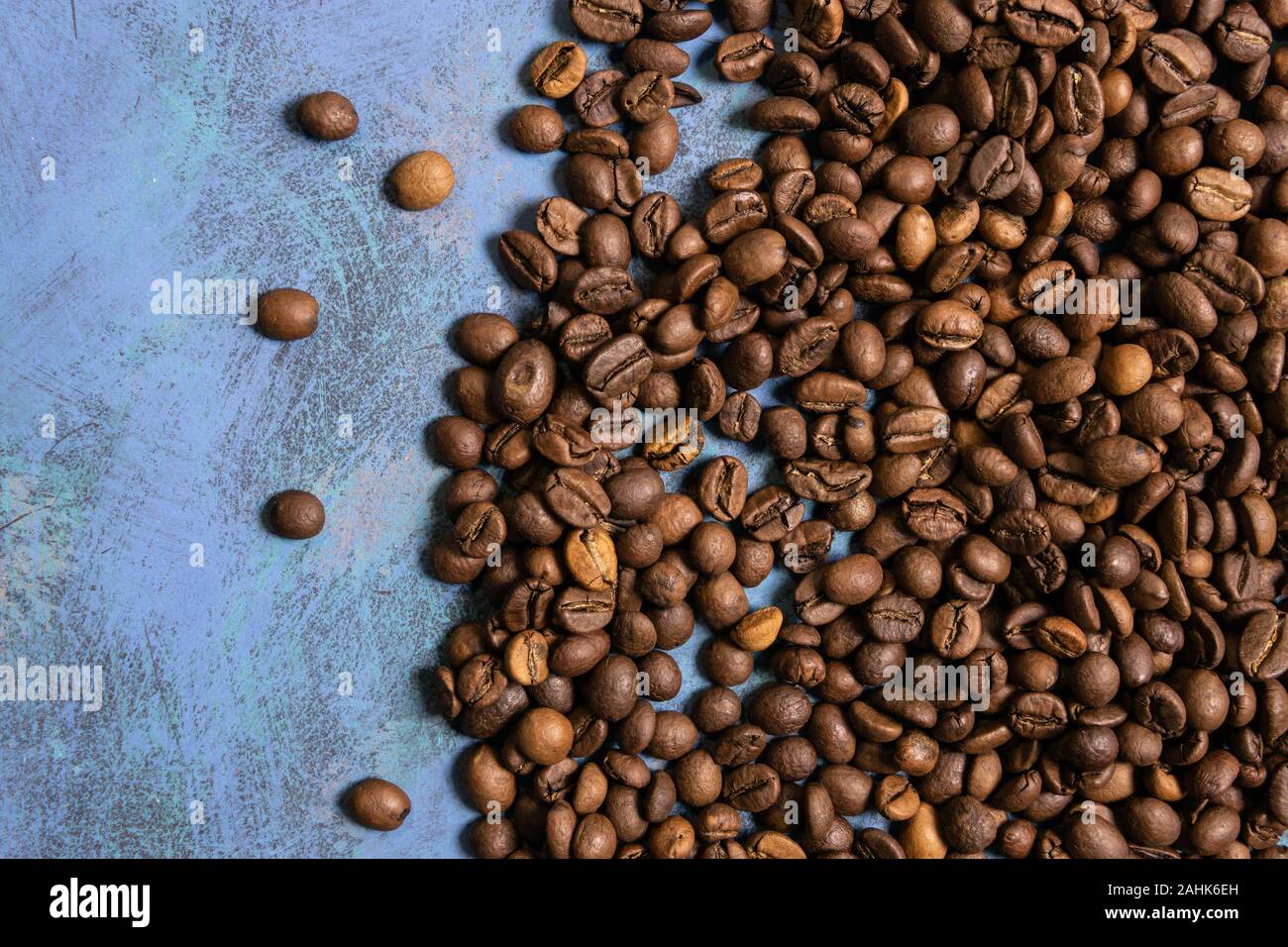 Roasted coffee beans in bulk on a blue background. dark cofee roasted ...