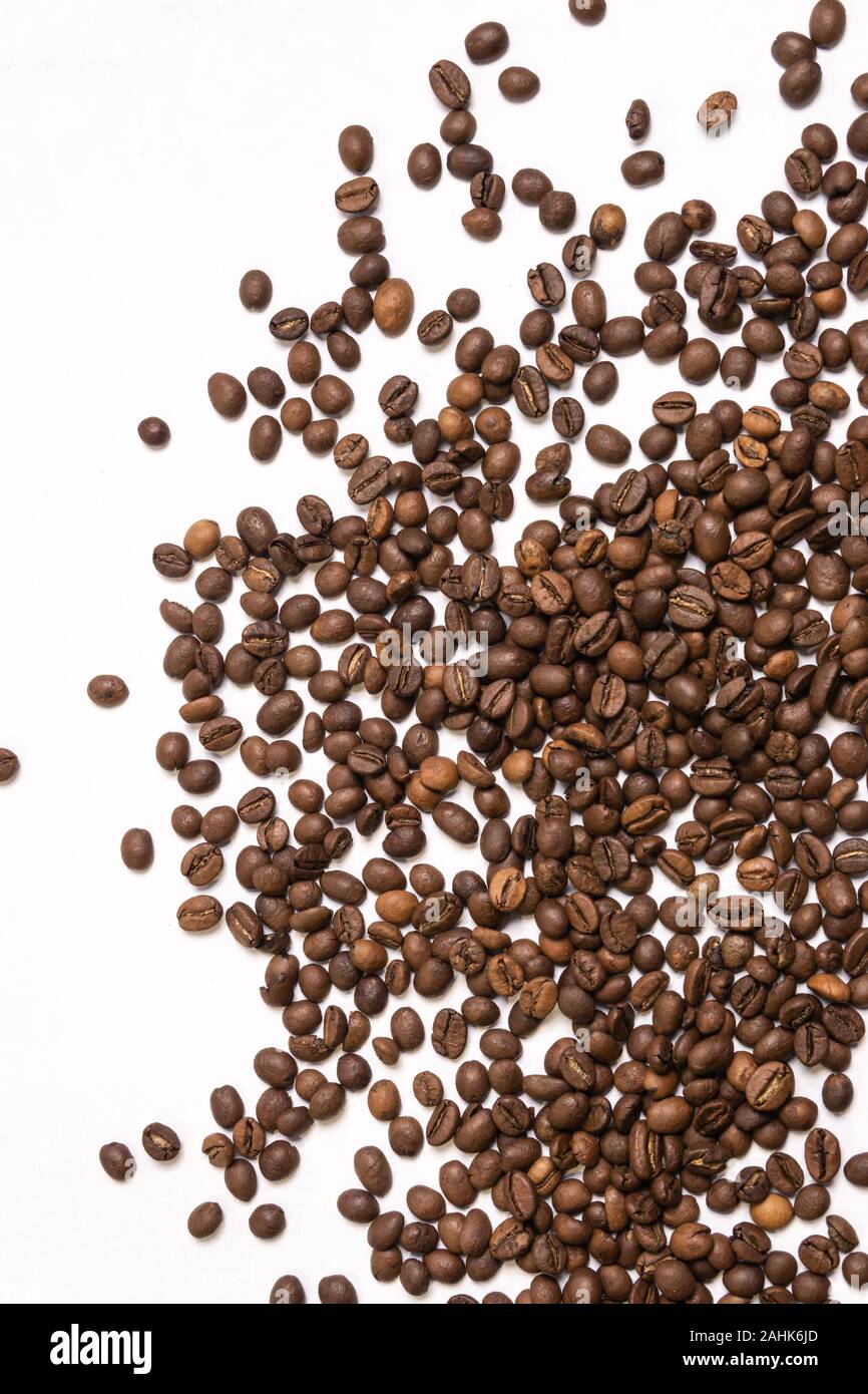 Roasted coffee beans in bulk on a light blue background. dark cofee ...