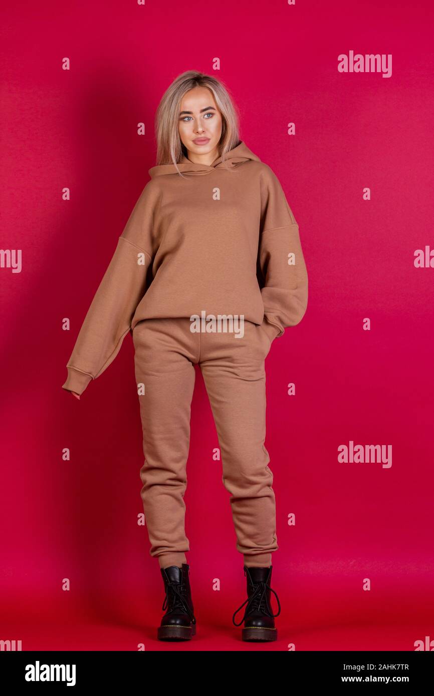 blonde girl in a brown suit on a red background Stock Photo