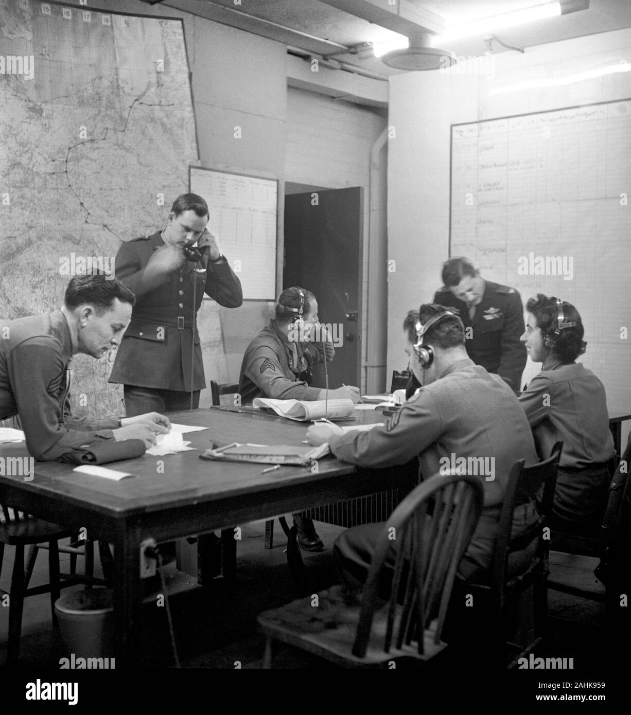 Military Officers and staff including a Woman, Staff Sergeant Dorothy Clark, seated around Table in U.S. 8th Air Force Headquarters Operation Room, possibly outside London, England, during World War II, photograph by Toni Frissell, January 1945 Stock Photo