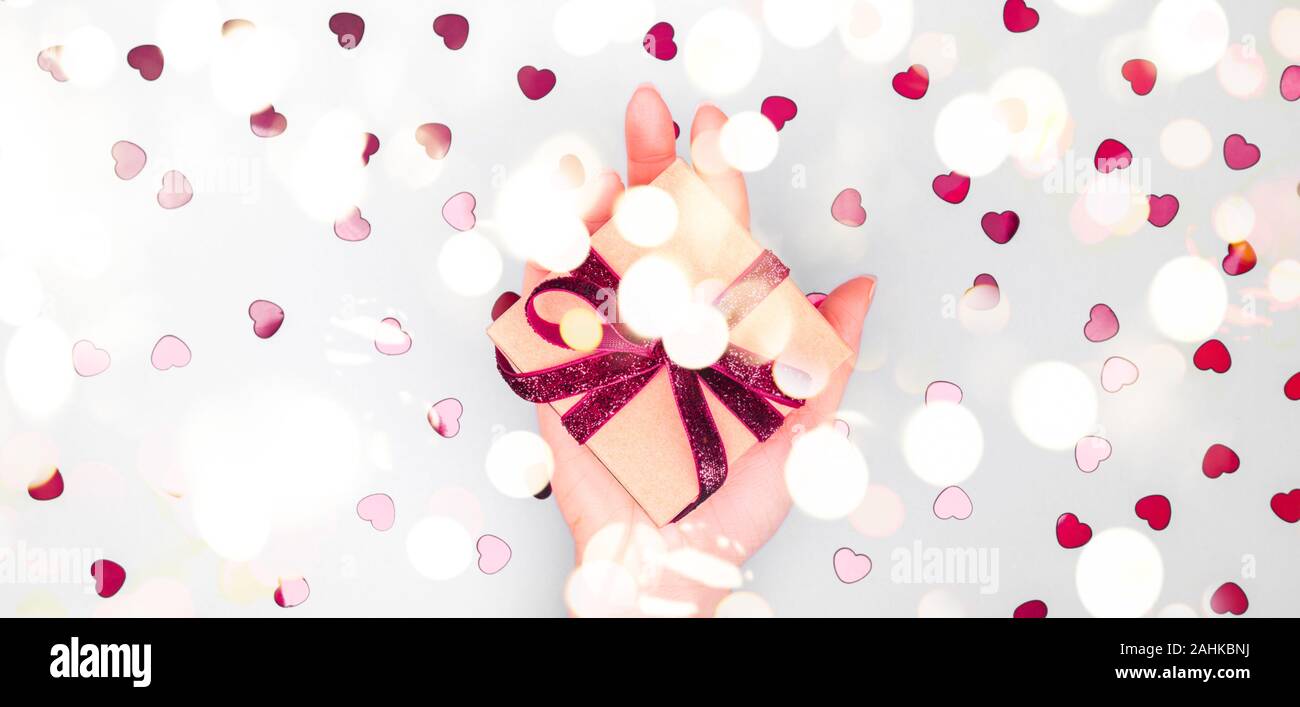 Craft box with dark red velvet ribbon bow in female hand. Valentine day ...