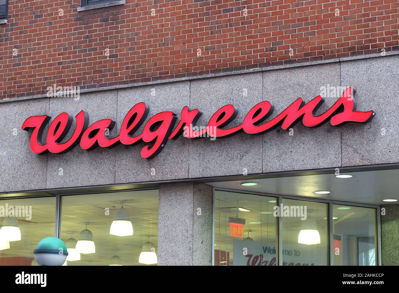 The Walgreens logo on a building with brick and granite construction in