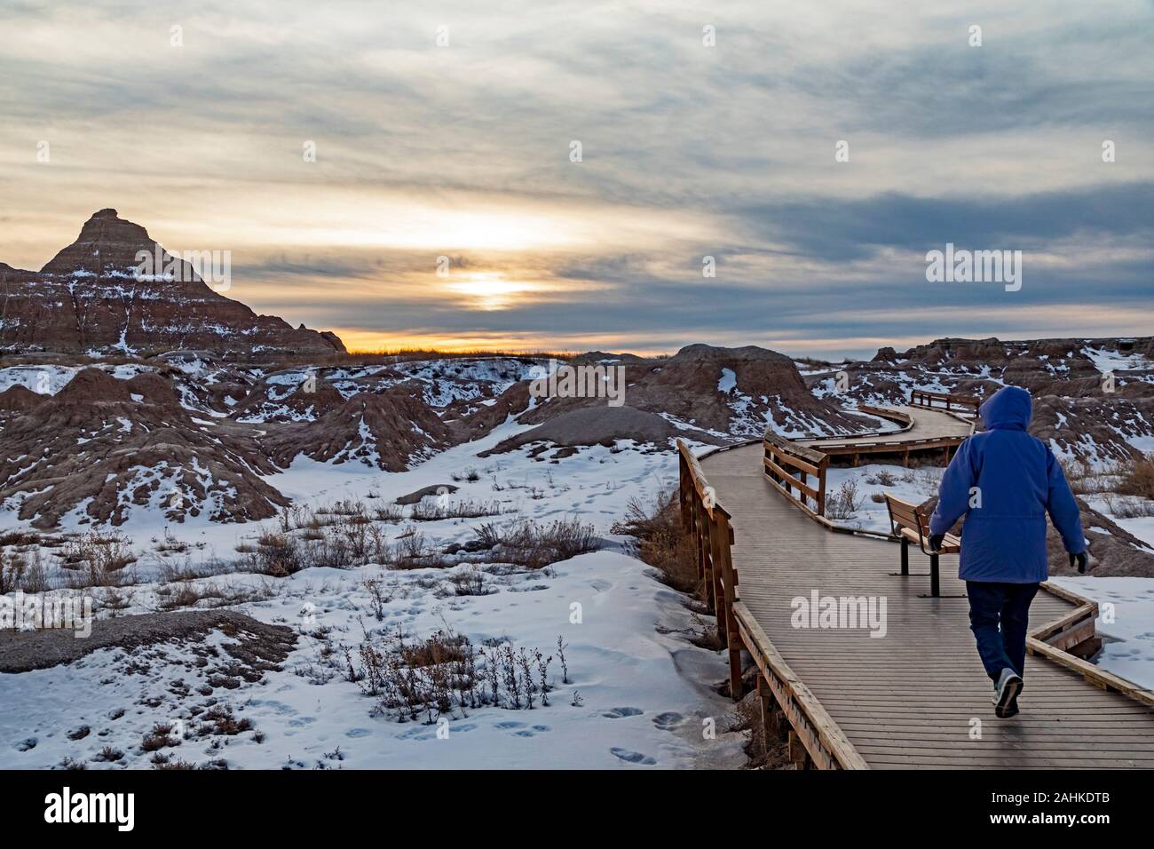 Badlands National Park In Winter A Visitor Walks On A Boardwalk Part badlands-national-park-in-winter-a-visitor-walks-on-a-boardwalk-part