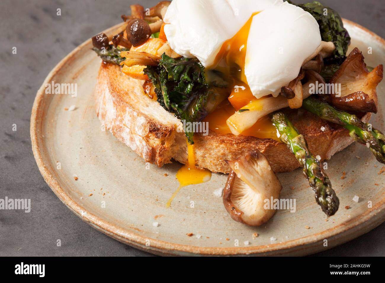 A poached egg on sourdough bread with asparagus and mushrooms Stock Photo