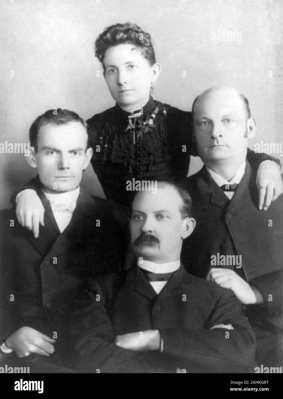 Members of the James–Younger Gang, sitting left-to-right: Bob Younger, Cole Younger, Jim Younger, members of the James–Younger Gang. Standing: Henrietta Younger. Stock Photo