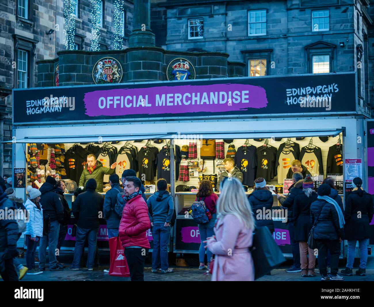 People buying merchandise for Edinburgh Hogmanay at street stall selling official goods, Royal Mile, Edinburgh, Scotland, UK Stock Photo