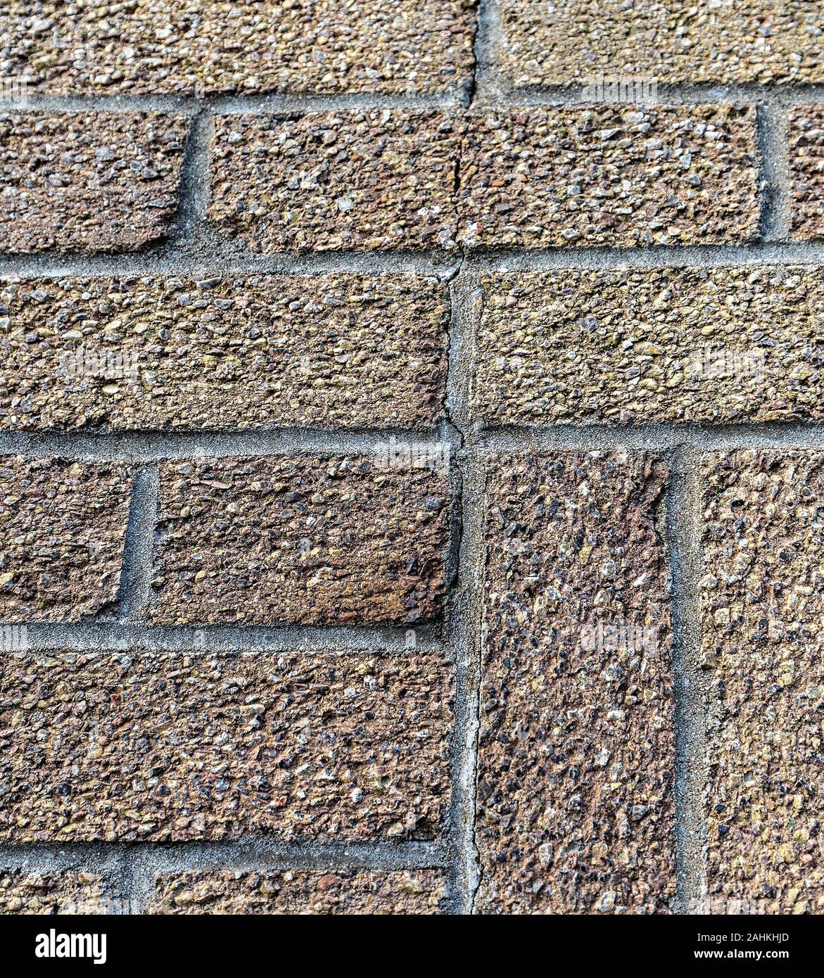 Crack running through bricks and mortar of house wall, UK Stock Photo