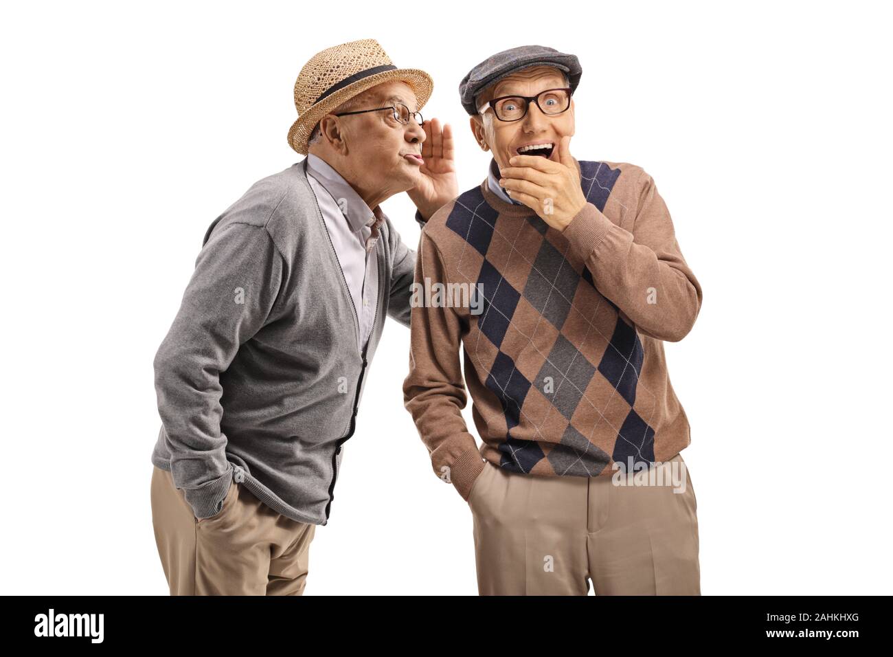 Elderly gentleman whispering a secret to another elderly man isolated on white background Stock Photo