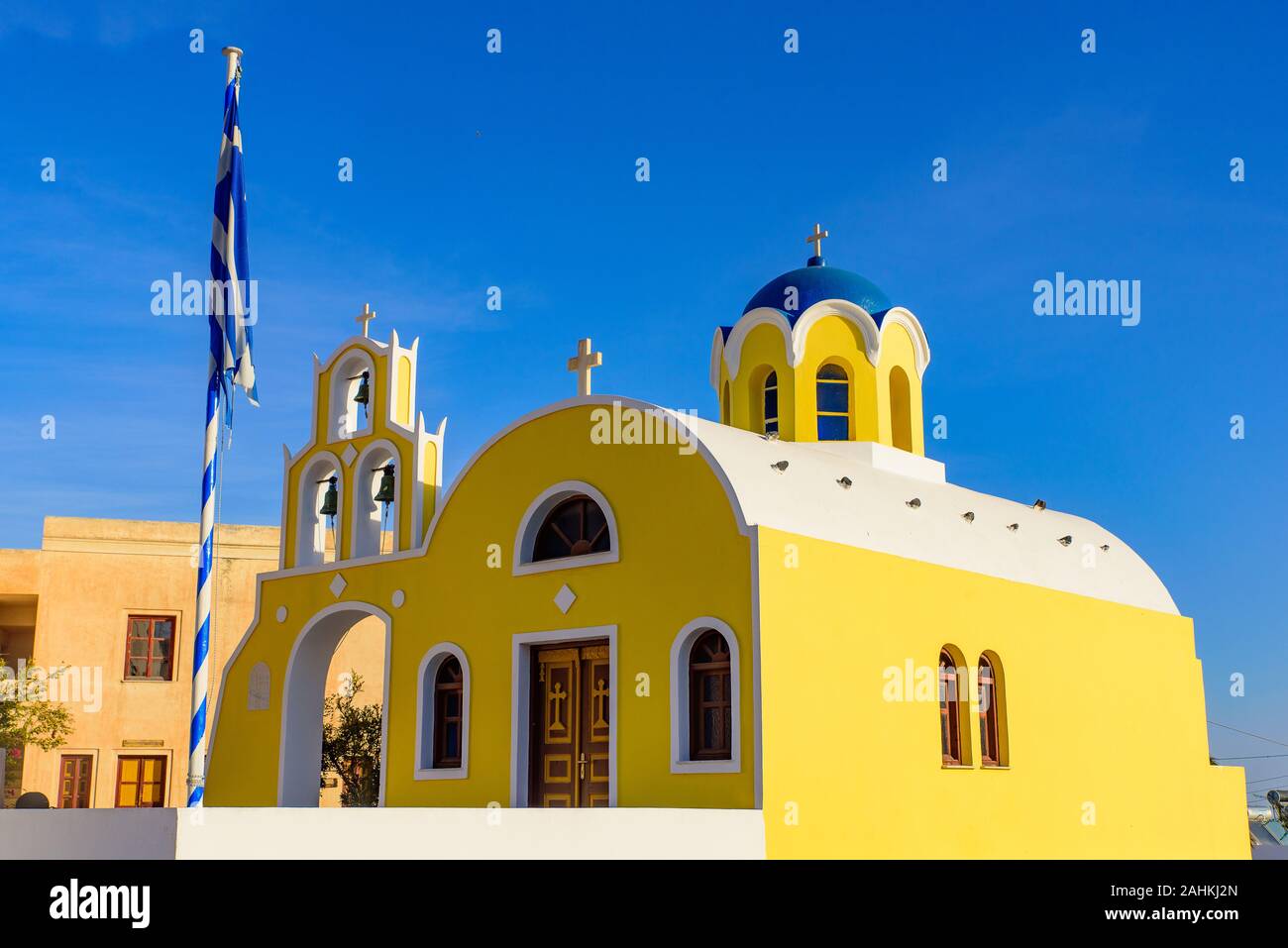 Yellow church with blue dome in Oia, Santorini, Greece Stock Photo