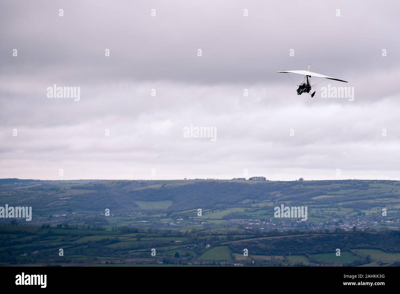 Person flying away into the horizon on a small aircraft single seat microlight as a hobby or sport in the air Stock Photo