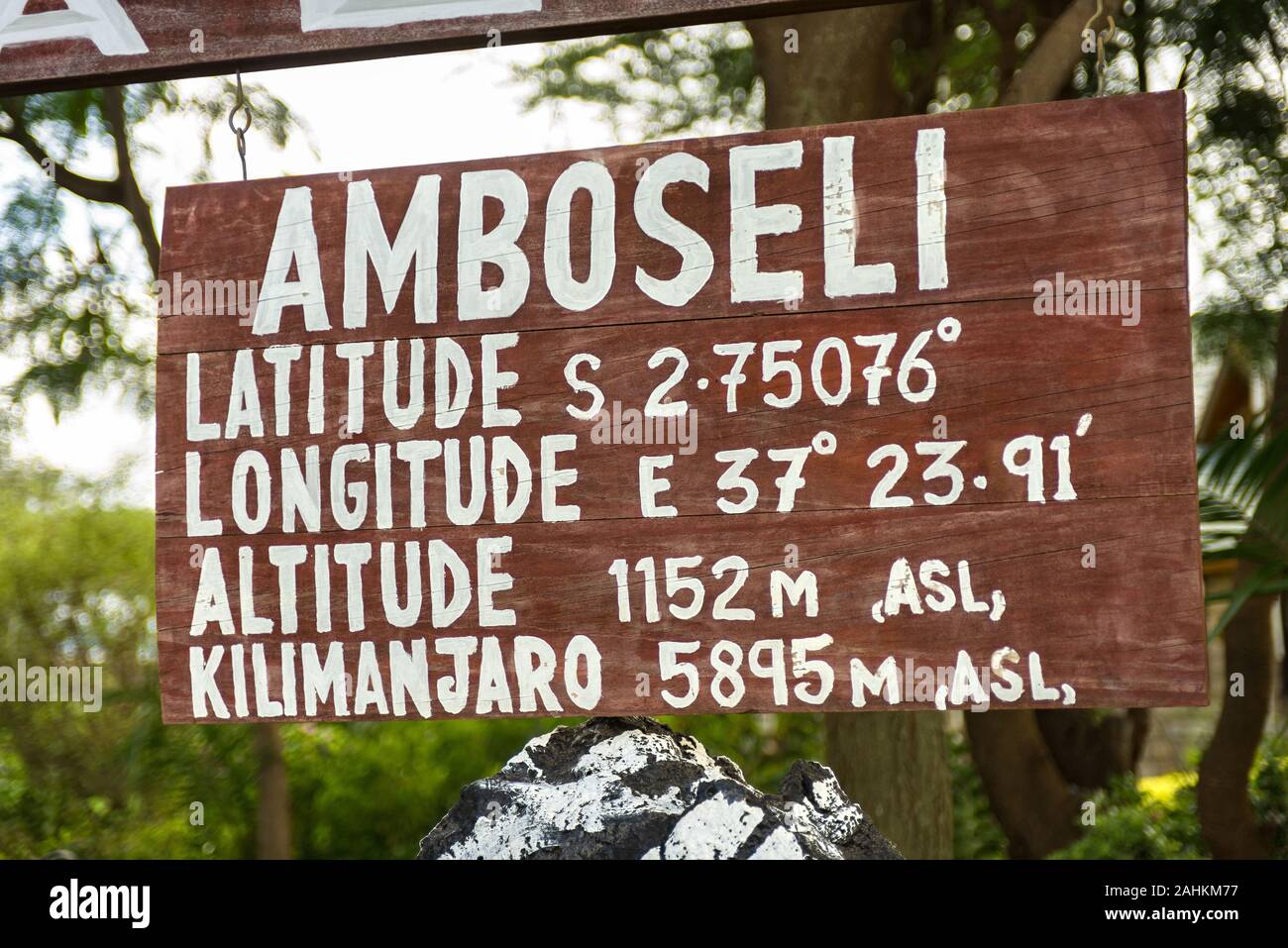 Wooden sign with latitude, longitude and altitude location details of Amboseli and Mount Kilimanjaro, Kenya, East Africa Stock Photo