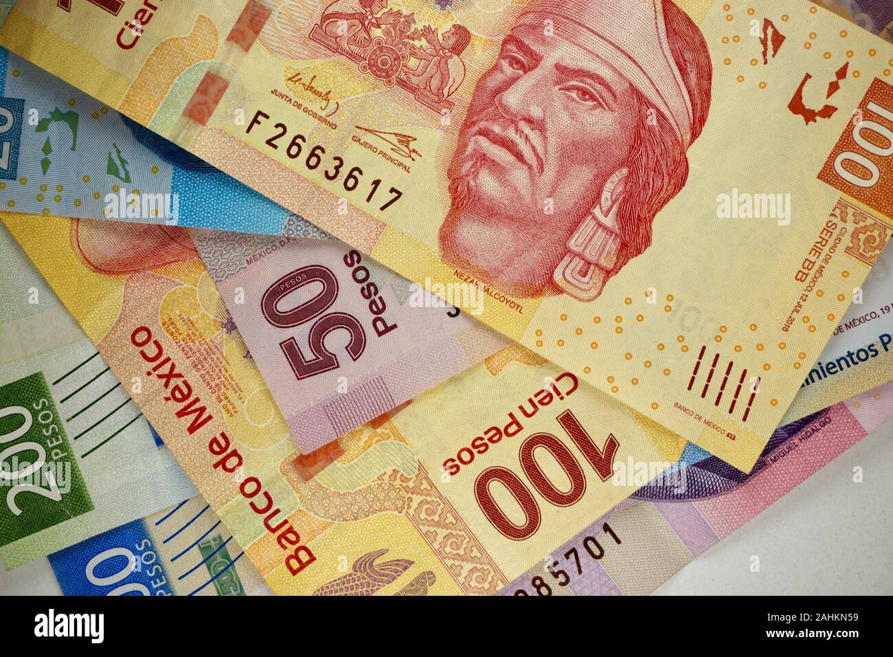 Many mexican pesos bills spread randomly over a flat surface Stock Photo
