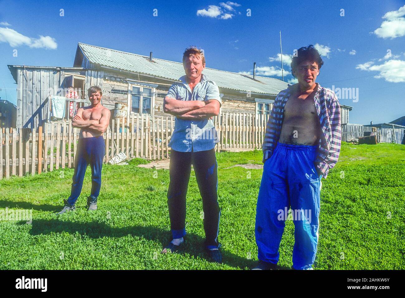 Three Siberian men stand outside of a modest house near the Arctic Circle in the Krasnoyarsk Krai. Stock Photo