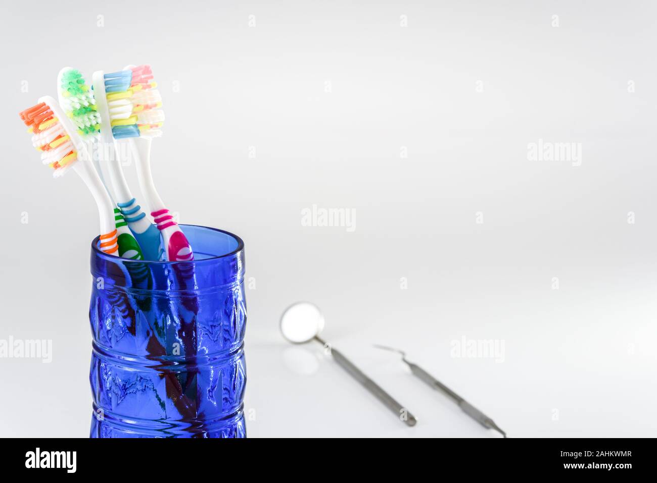 Toothbrushes in a glass and dental care set isolated on white ...