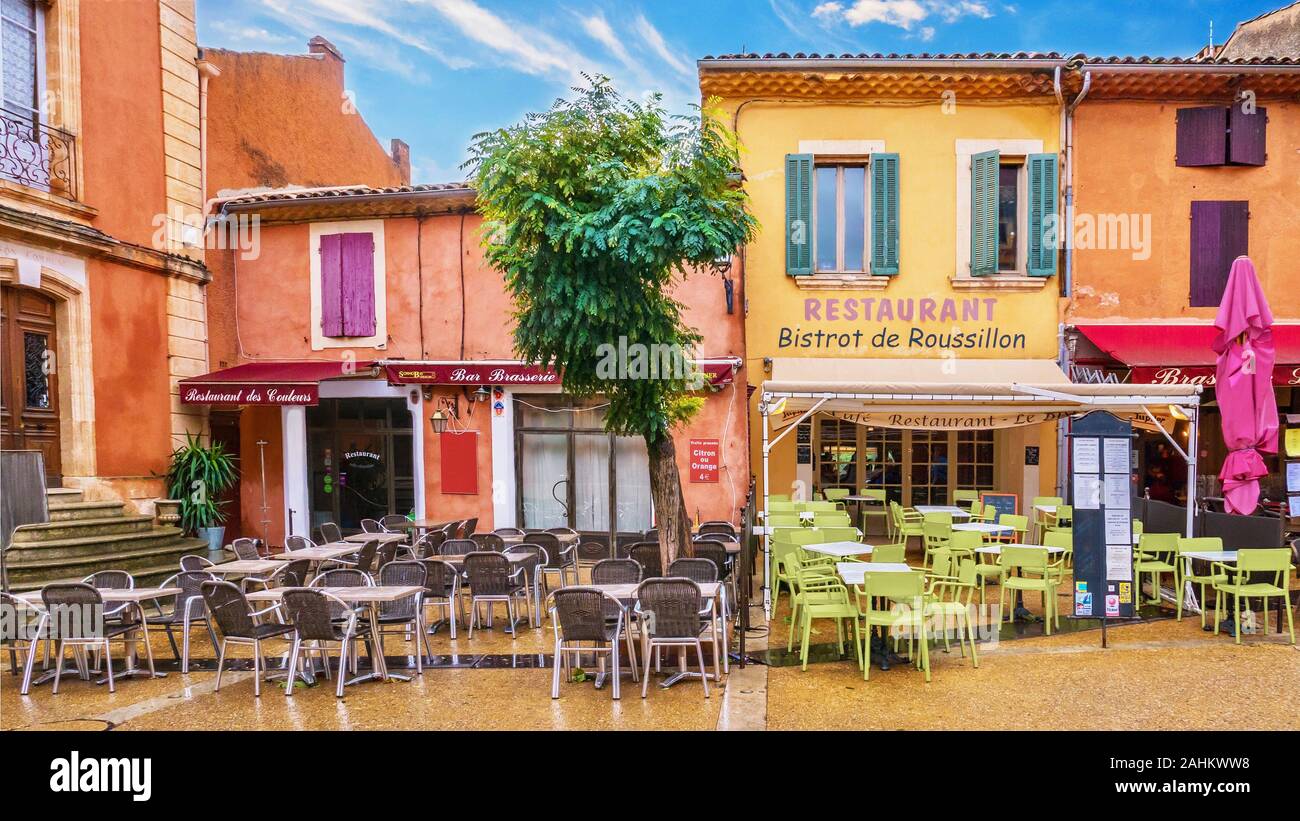 Roussillon, France - October 14, 2016. Street view of colourful restaurants painted with locally mined ochre pigment. Stock Photo