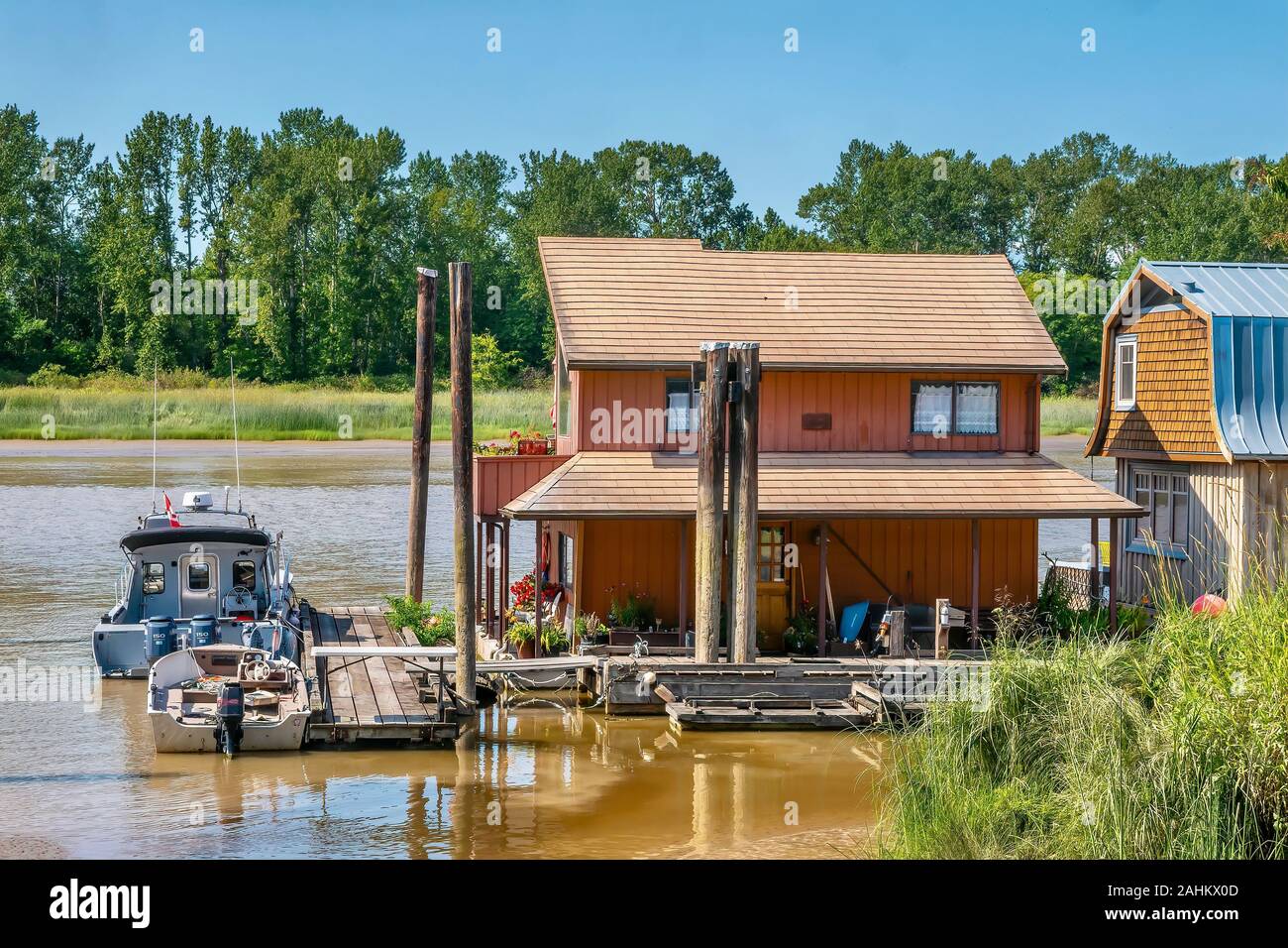 Delta, B.C., Canada - July 20, 2019. Floating homes moored on the Fraser River, a housing alternative growing in popularity as real estate prices rise Stock Photo