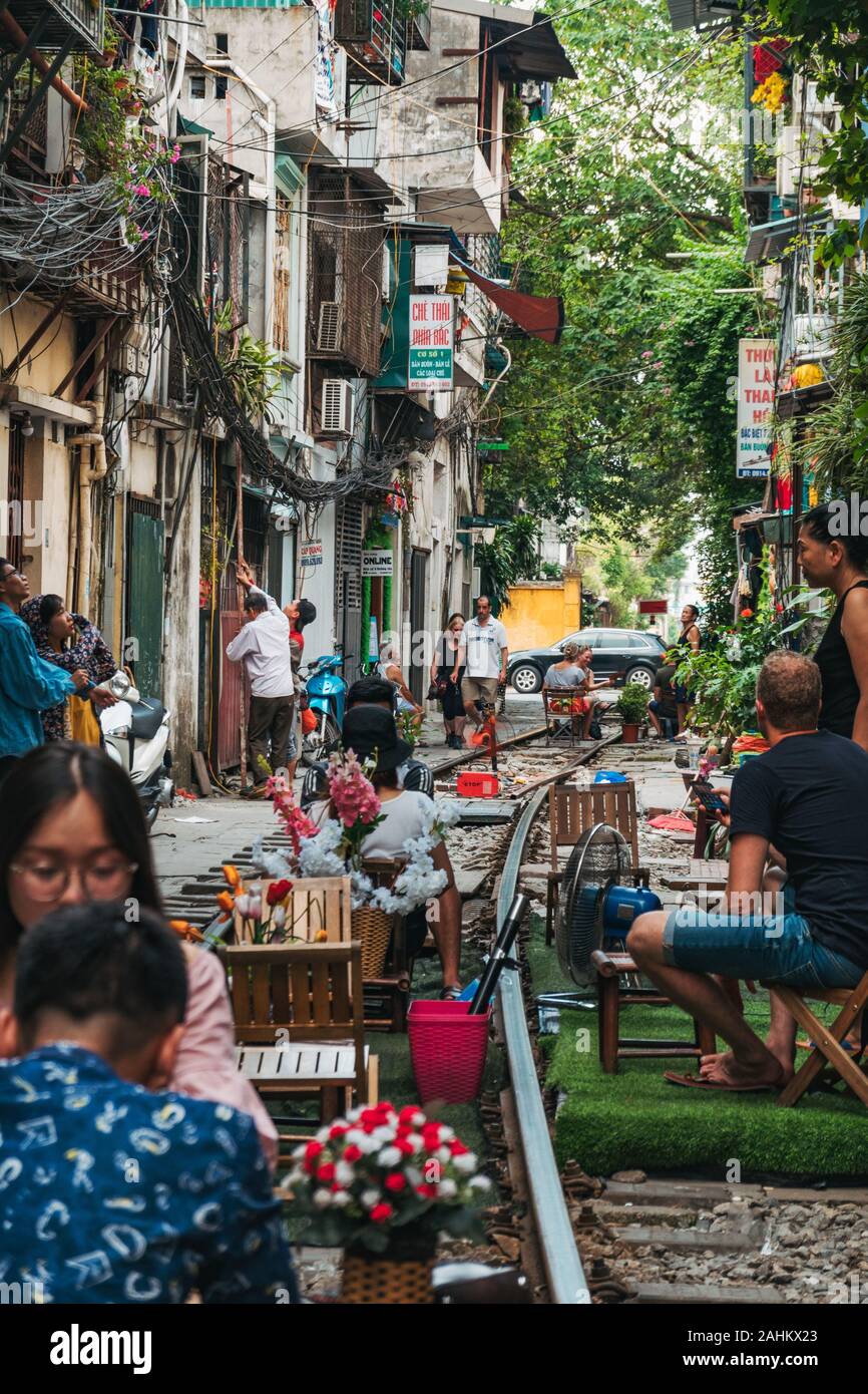 Tourists enjoy outdoor cafe seating on the tracks in Hanoi's infamous Train Street, Ngo 224 Le Duan, in the Old Quarter Stock Photo