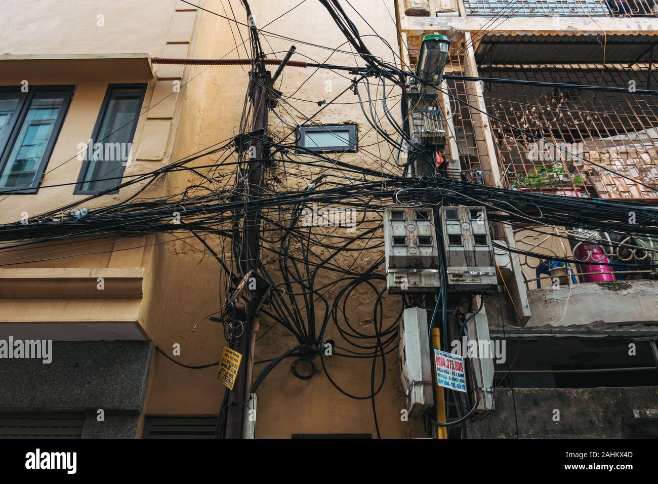 A sprawling tangle of residential power lines and internet cables in Hanoi, Vietnam Stock Photo