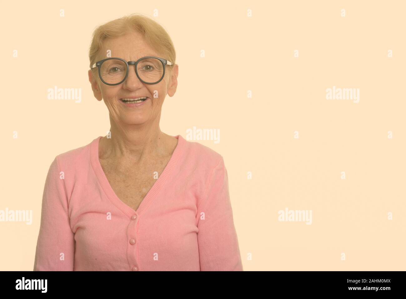 Happy senior nerd woman smiling and laughing while wearing geeky eyeglasses Stock Photo