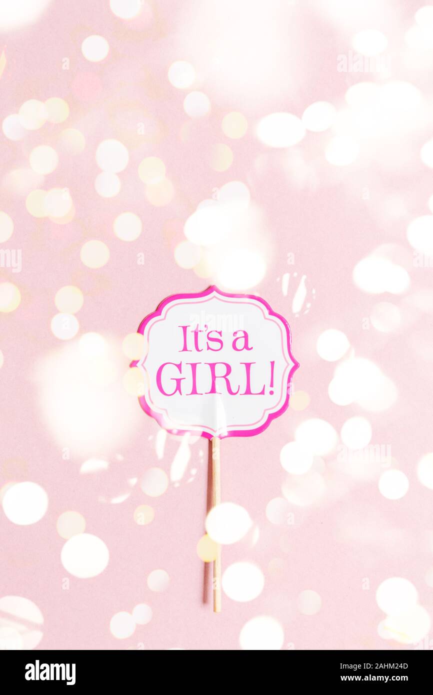 It's a girl sign at the baby shower party. Pink solid background. Baby