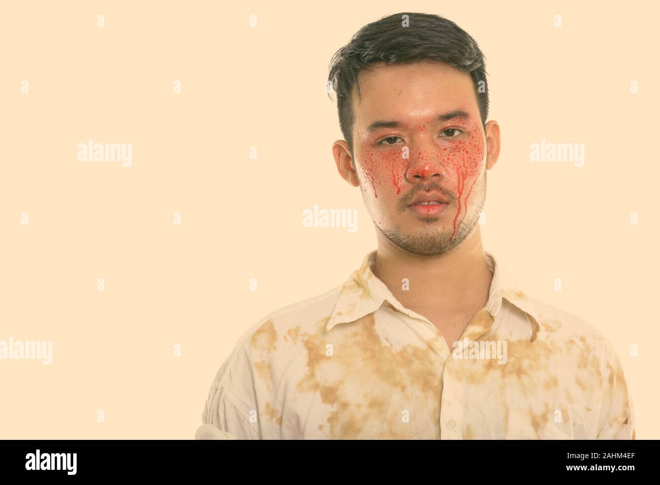 Studio shot of young crazy Asian man with blood on face Stock Photo - Alamy