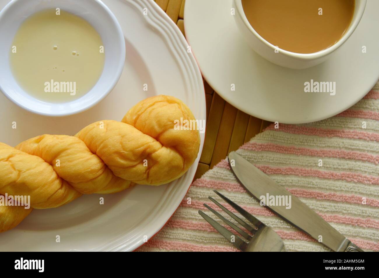 twist bread dipping with sweetened condensed milk and coffee cup Stock